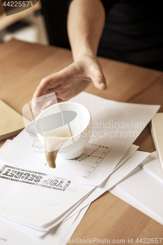 Image of Coffee in white cup spilling on the table in the morning working day at office table