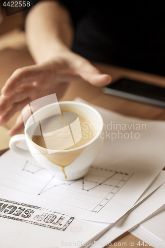 Image of Coffee in white cup spilling on the table in the morning working day at office table