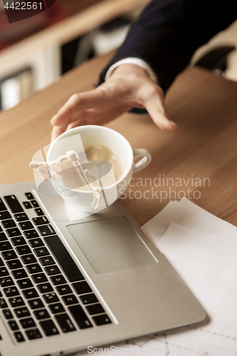 Image of Coffee in white cup spilling on the table in the morning working day at office table