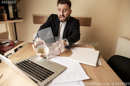 Image of Coffee in white cup spilling on the table in the morning working day at office table