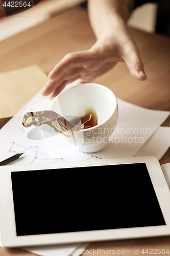 Image of Coffee in white cup spilling on the table in the morning working day at office table