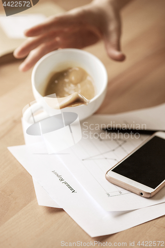 Image of Coffee in white cup spilling on the table in the morning working day at office table