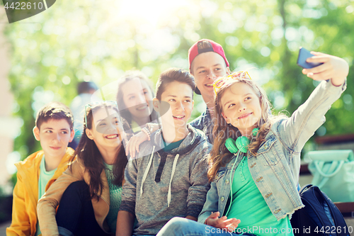 Image of happy teenage students taking selfie by smartphone