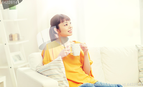 Image of happy asian woman drinking from tea cup