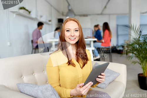 Image of redhead woman with tablet pc working at office