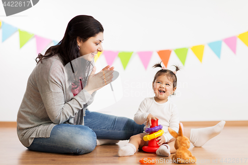 Image of mother and baby daughter playing with pyramid toy