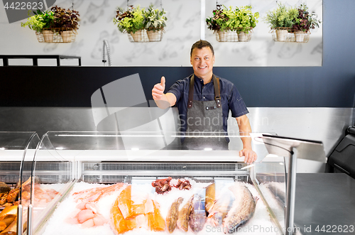 Image of seafood seller at fish shop showing thumbs up