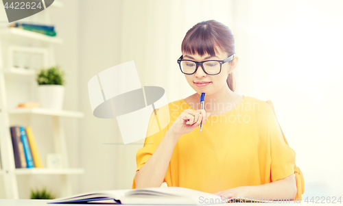 Image of happy asian young woman student learning at home