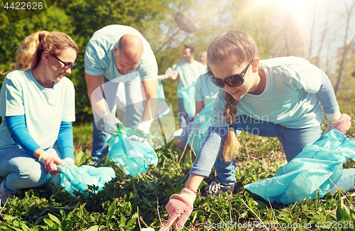 Image of volunteers with garbage bags cleaning park area