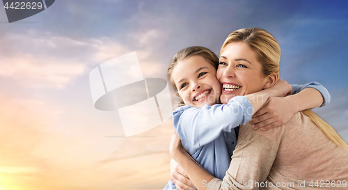 Image of happy smiling mother hugging daughter over sky