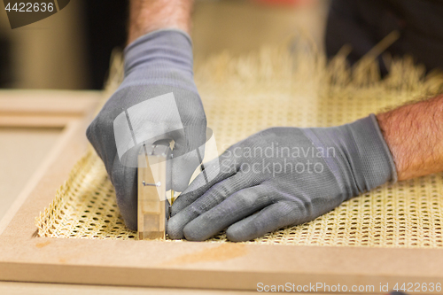 Image of assembler with staple gun making furniture