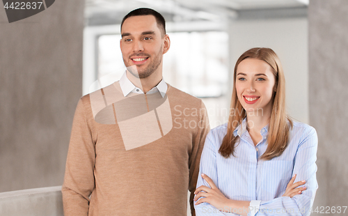 Image of smiling businesswoman and businessman at office