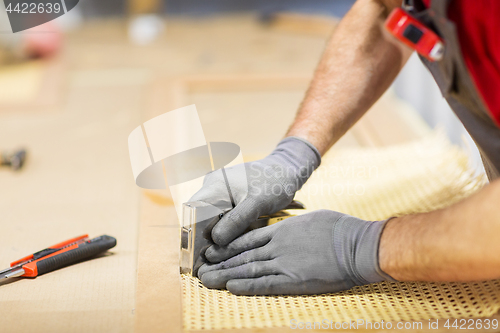 Image of assembler with staple gun making furniture