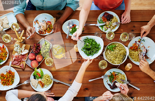 Image of group of people eating at table with food