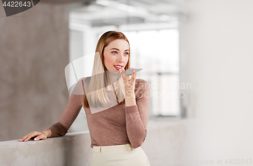 Image of woman using voice recorder on smartphone at office