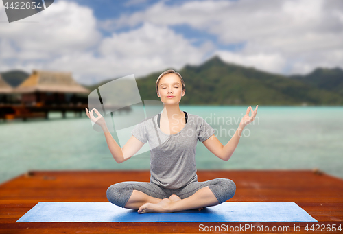 Image of woman making yoga in and meditating lotus pose