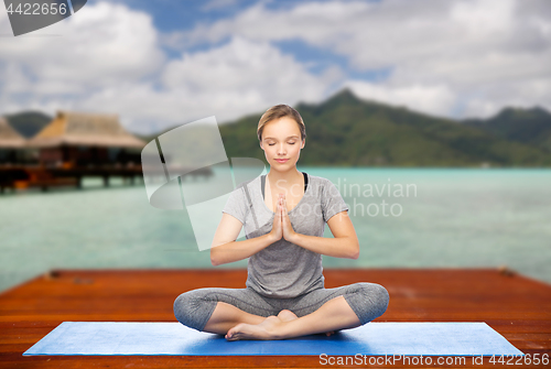 Image of woman making yoga in and meditating lotus pose