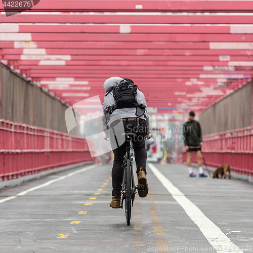 Image of Man riding his bike in the cycling lane on Williamsburg Bridge, Brooklyn, New York City.