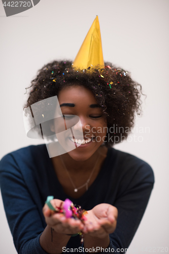 Image of African American woman blowing confetti in the air