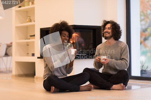 Image of multiethnic couple  in front of fireplace