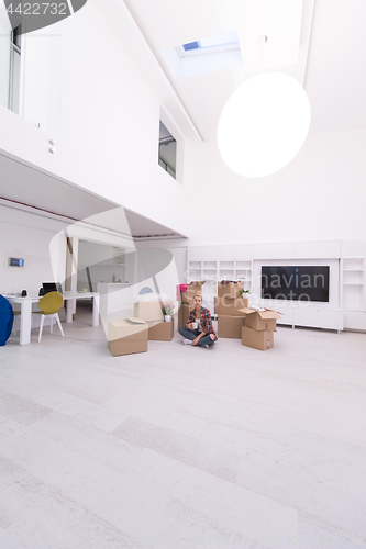 Image of woman with many cardboard boxes sitting on floor