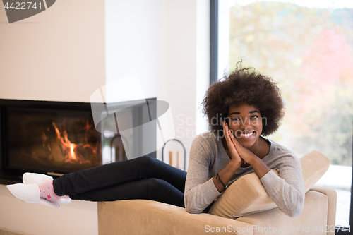 Image of black woman in front of fireplace