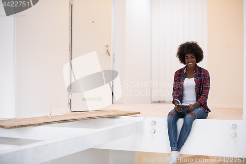 Image of black woman sitting on stairs at home