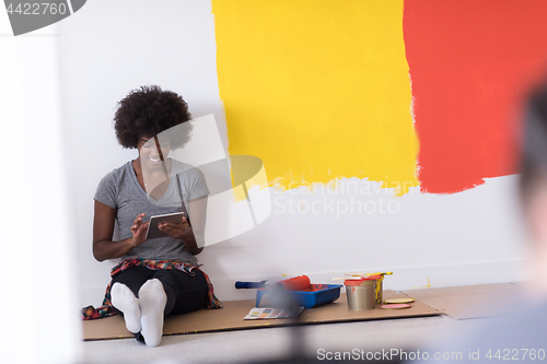 Image of back female painter sitting on floor