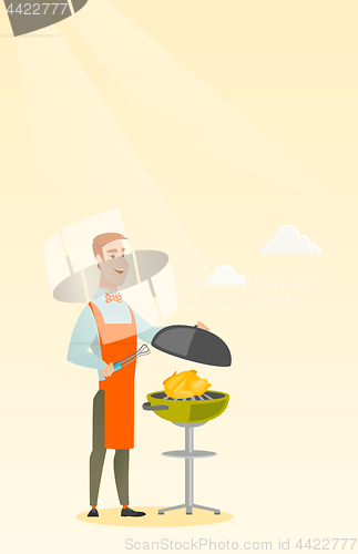 Image of Man cooking chicken on barbecue grill.