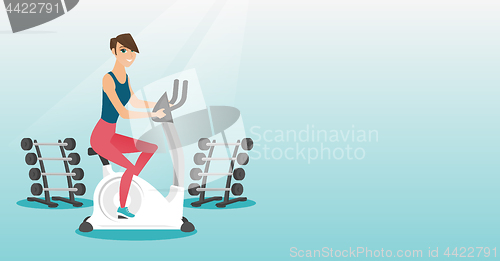 Image of Young woman riding stationary bicycle.