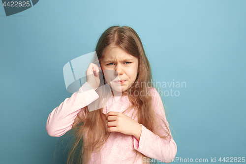 Image of The Ear ache. Teen girl on a blue background. Facial expressions and people emotions concept