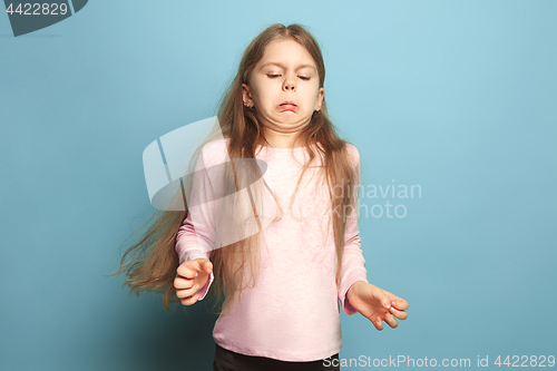 Image of The disgust. Teen girl on a blue background. Facial expressions and people emotions concept