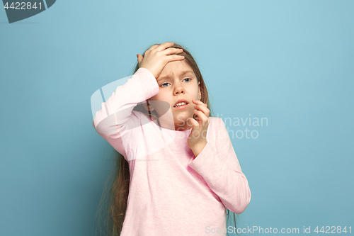Image of The headache. Teen girl on a blue background. Facial expressions and people emotions concept
