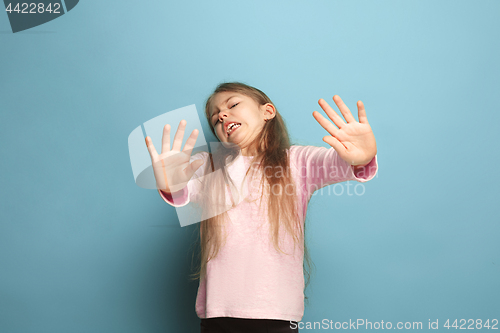 Image of The disgust. Teen girl on a blue background. Facial expressions and people emotions concept