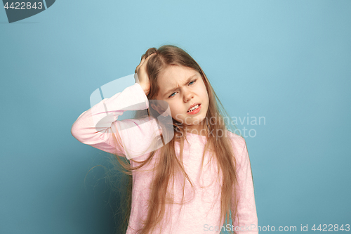 Image of The headache. Teen girl on a blue background. Facial expressions and people emotions concept