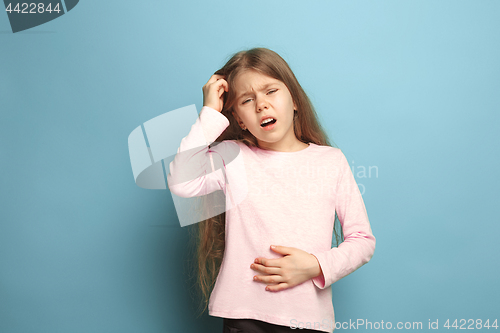 Image of The abdominal pain. Teen girl on a blue background. Facial expressions and people emotions concept