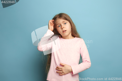 Image of The abdominal pain. Teen girl on a blue background. Facial expressions and people emotions concept