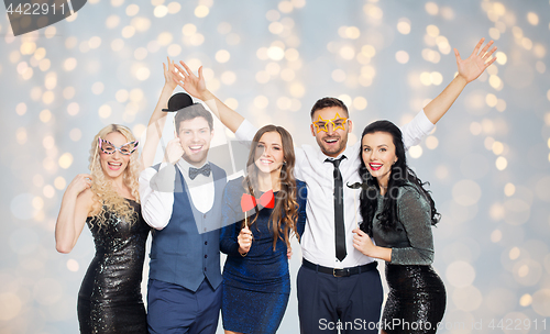 Image of happy friends with party props posing over lights