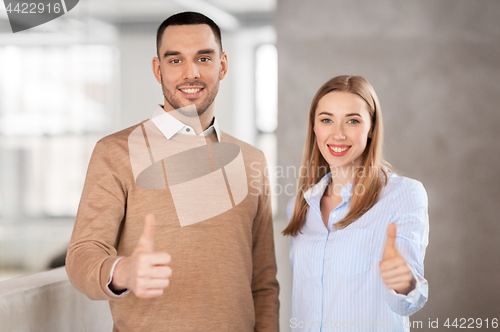 Image of businesswoman and businessman showing thumbs up