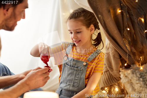 Image of family playing tea party in kids tent at home