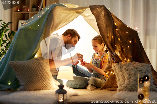 Image of family playing tea party in kids tent at home