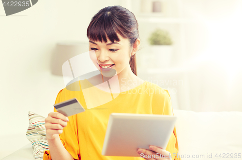 Image of happy asian woman with tablet pc and credit card