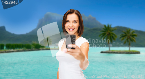 Image of woman taking selfie by smartphone on bora bora