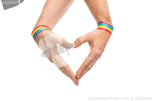 Image of male hands with gay pride wristbands showing heart