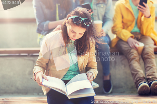 Image of high school student girl reading book outdoors