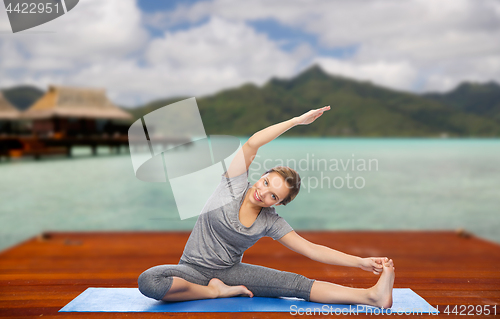 Image of happy woman making yoga and stretching outdoors