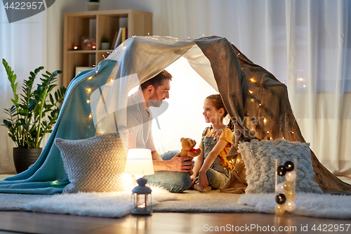 Image of happy family playing with toy in kids tent at home