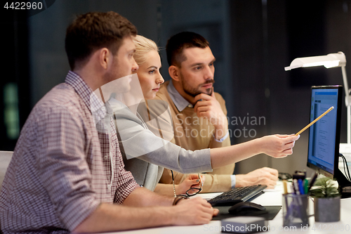 Image of business team with computer working late at office