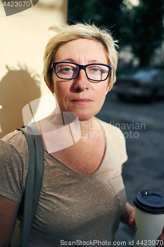 Image of Senior woman with beverage looking at camera