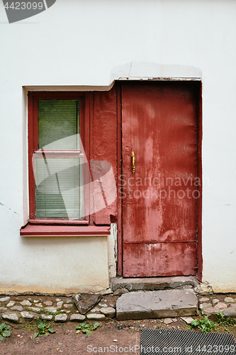 Image of White wall with red window and door